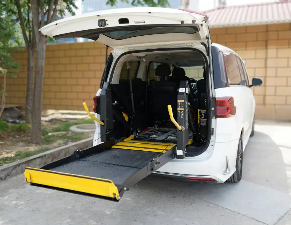 A white van with its rear hatch open reveals a yellow and black wheelchair lift extended onto the pavement, showcasing a wheelchair accessible vehicle ideal for safe and convenient transport.